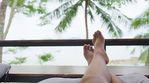 First person view of someone relaxing with their feet propped up on a balcony Stock Footage 344138766