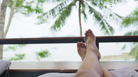 First person view of someone relaxing with their feet propped up on a balcony Stock Footage 344138779