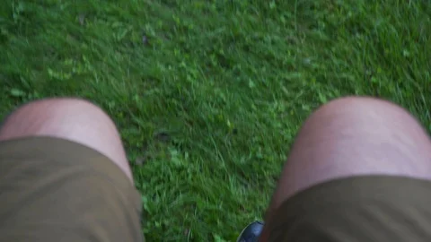 First person view of swinging on a swing, green grass Stock Footage 120701019