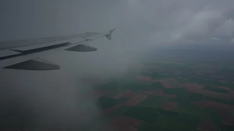 First-person view through window on wing of plane passing through gloomy clouds Stock Footage 244387051