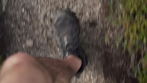 First person view from top towards hiking shoes during a hike on a rocky trail Stock Footage 237437818