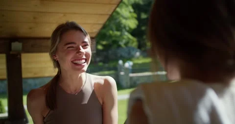 First-person view two blonde girls sit in a gazebo and communicate in nature Video stock 246151180