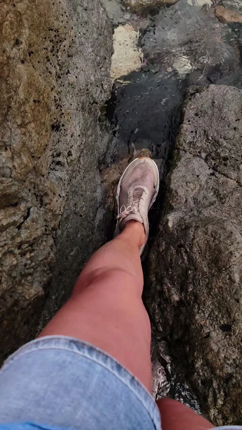 First person view walking across wet rocks in shallow water. vertical. Stock-Footage 336190253