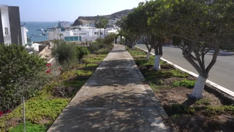 First person view walking along the sidewalk of a condominium on the beach next Stock Footage 155817760