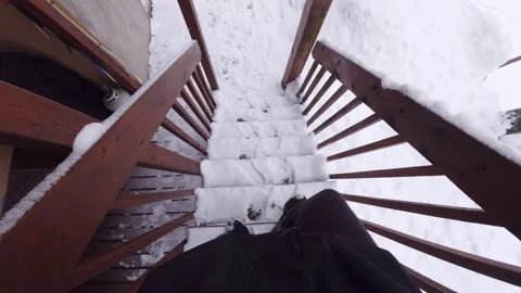 First person view walking down snowy stairs during winter Stock Footage 326377607