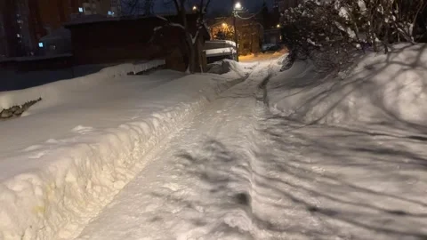 First person view walking down a snowy path at night Stock Footage 328477178