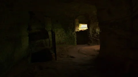 First person view of walking towards grated windows inside of a dimly lit room Video stock 309358401