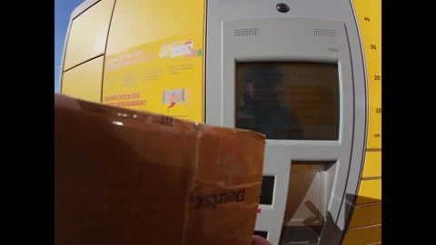 First person view of a woman using a yellow DHL parcel locker in Germany on a Stock Footage 316643728