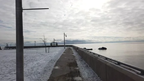 First Person Walking Down Ocean Waterfront Pier In Wintertime Cloud Covered Sky Video stock 222421962