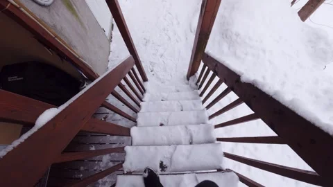 First person walking down snow covered stairs in winter Stock Footage 326377542