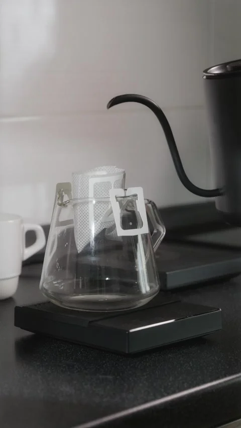 First pour over drip coffee bag on glass server Stock Footage 338395134