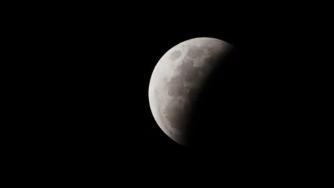 A first quarter moon on a clear dark night with half the moon in light and half Stock Footage 332780992
