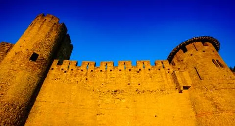 The first rays of dawn sunlight strike the walled Cité de Carcassonne, France  Stock Photos
