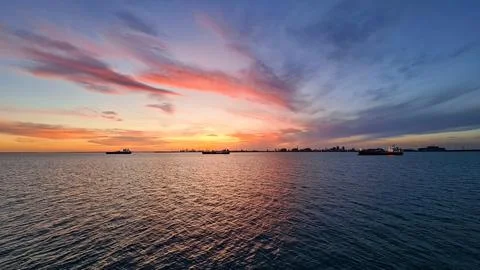 The first rays of the rising sun against the background of distant shore fr.. Stock Photos