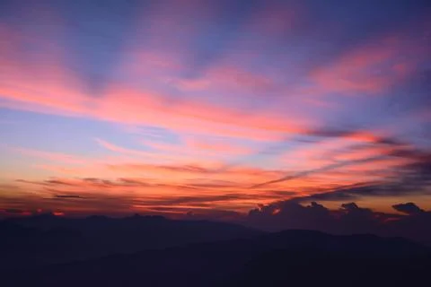 First rays of the rising sun. Misty mountains in the morning. Sunrise at the Stock Photos