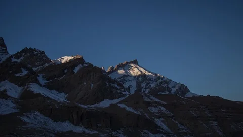First rays of sun falling on the mountains in winter Vidéo 121964985