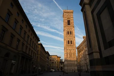 First rays of sun hit Giotto's Bell tower (Campanile) in Florence, Italy, at Stock Photos