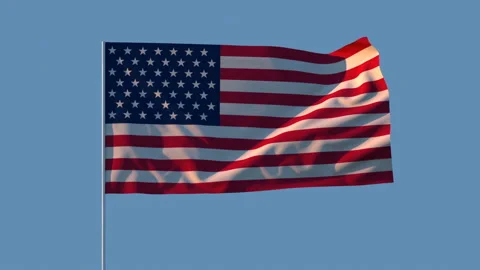 The first rays of the sun illuminate the US flag on a blue background. Stock Footage 130002095