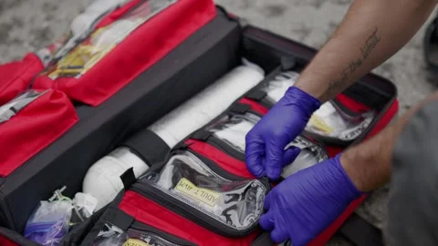 A first responder opens up their emergency rescue kit and removes a life-saving Stock Footage 308625662
