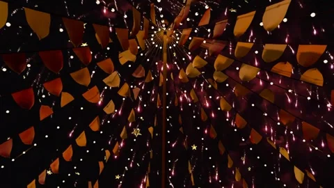 First rockets launching, fireworks bursting, canopy framing upward, flags Stock Footage 340654573