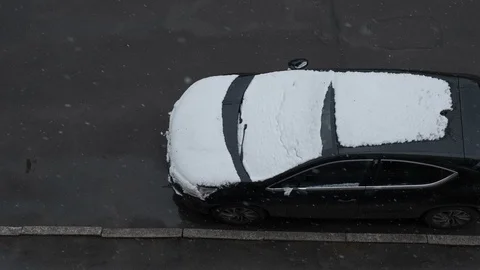 The first snow falls on the black car. the view from the top. Stock Footage 118370480