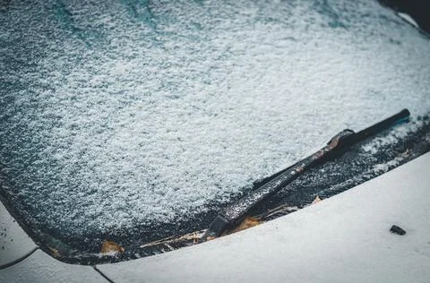 The first snow on the windshield of the car. The onset of winter. The car snowed Stock Photos