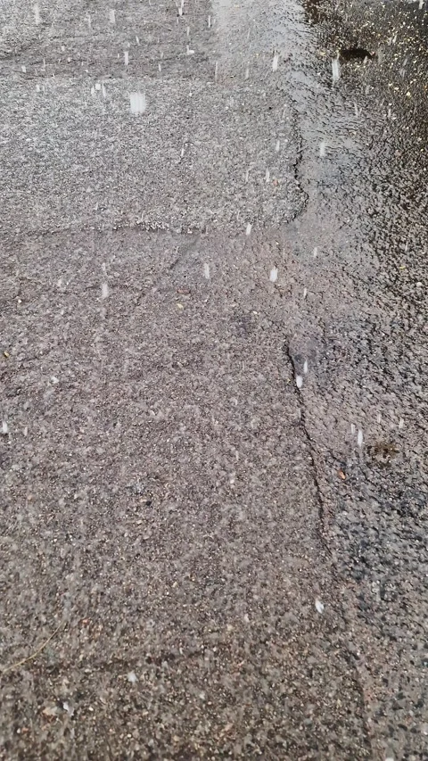 First Snowflakes Falling on Wet Cracked Asphalt Pavement 스톡 동영상 325223885