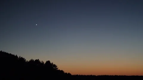 First star in the sunset evening sky over the calm lake in slow motion panoramic Stock Footage 106714296