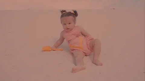 A first step of baby at the sand beach. A little girl walks the sand Vidéo 73909655