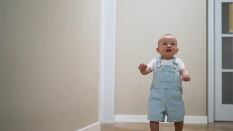 First steps. baby takes first steps at home on the floor. Child learns to walk Stock Footage 255239141