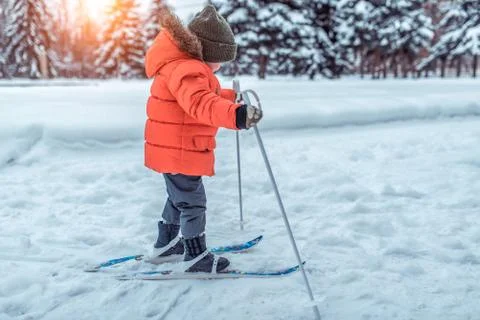 The first steps of a boy child 4-6 years old on children's skiing with sticks Foto stock
