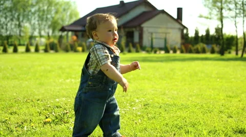 First steps cute baby in yard in at the village Stock Footage 63641108