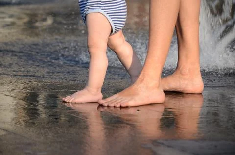 The first steps of a small child with mom Stock Photos