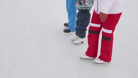 The first steps of a young child on skates. Mom and dad teach a child to skate Vidéo 85519904