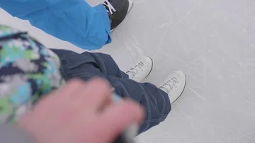 The first steps of a young child on skates. Mom and dad teach their child to Vidéo 85569354