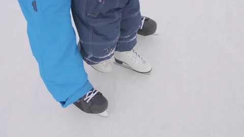 The first steps of a young child on skates. Dad teaches the child to skate and Vidéo 85636131