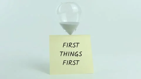 First Things First written on yellow sticky note placed on hourglass Stock Footage 313483179
