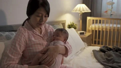 First-time mom seated in bedroom holding Stock Footage 140890781