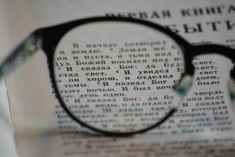 First verses of Genesis through the reading glasses Stock Photos