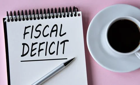 FISCAL DEFICIT - words written in a notebook on the background of a cup of co Stock Photos