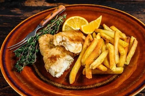 Fish and Chips british fast food with french fries and tartar sauce on a rustic Stock Photos