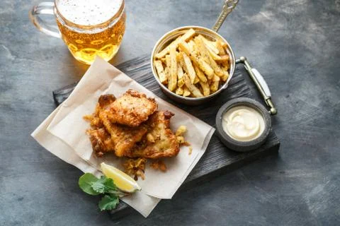 Fish and chips with mayo on crumpled paper. Stock Photos