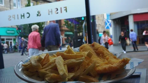 Fish and chips plate and people walking 스톡 동영상 125416100