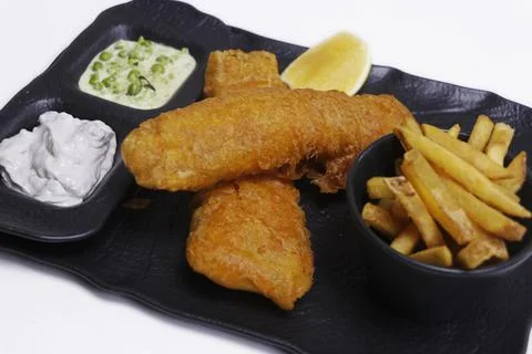 Fish and chips plate with battered fried cod fish and french fries with mushy Stock Photos