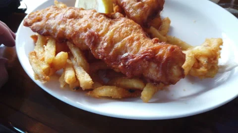 Fish and chips ready to be on white plate deep fried fish french fries Stock-Footage 214197586