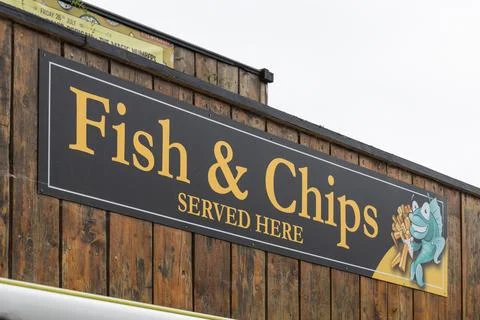 Fish and chips sign on a rustic wooden food stall exterior. Wareham, UK, 3 July Stock Photos