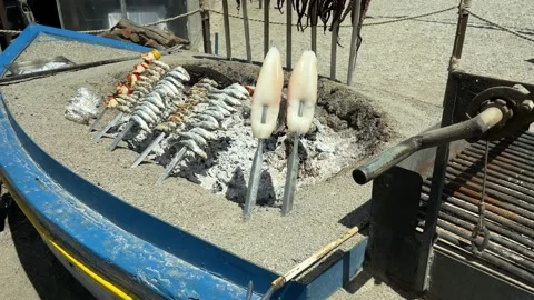 Fish and octopus being grilled over open fir Stock Footage 186780923