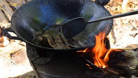 The fish are fried on a hot pan fire. Stockbeeldmateriaal 84044799