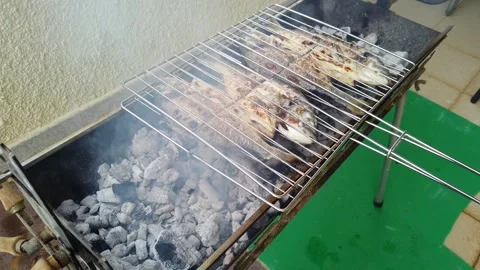 Fish BBQ Turning Over on Grill Stockbeeldmateriaal 332890786