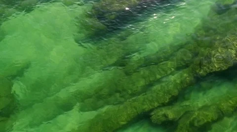 Fish in Beautiful emerald ocean wave on a rocky beach aerial view Stock Footage 64697343